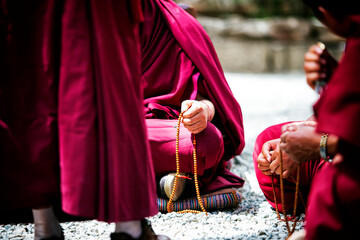 Buddhist monks holding prayer beads (mala) in deep devotion. Their serene expressions and...