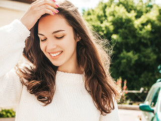 Closeup portrait of beautiful smiling brunette model. Trendy female posing in the street background...