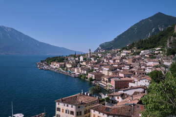 Summer aerial landscape of Limone sul Garda, a peaceful resort village by Lake Garda in Lombardy, Italy, with views of the Alps and clear skies.
