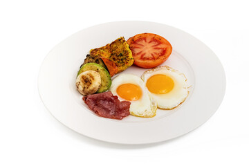 Rustic breakfast plate with fried eggs, grilled vegetables, and turkey bacon