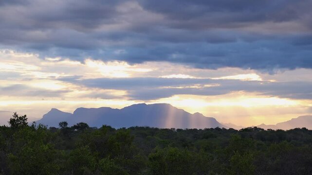 Nature background: Sun beams through clouds over vast forest landscape