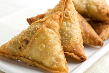 Close-Up View of Indian Deep Fried Breakfast Samosa with Flaky Layers on White Background