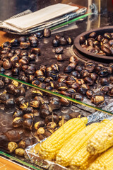 Vendors offer roasted chestnuts and corn at an oriental bazaar during a lively evening market.