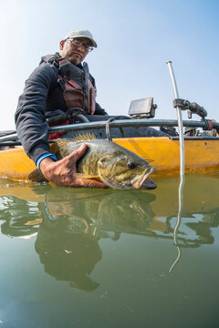 Kayak Angler Releases Small Mouth back into the Water