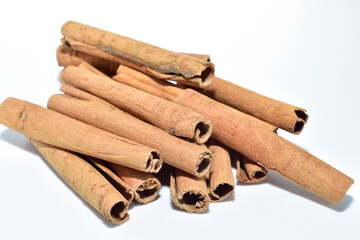 Dry sticks of aromatic cinnamon spice lie on a white background