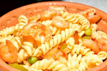Fusilli pasta with shrimps in a plate. Close-up.