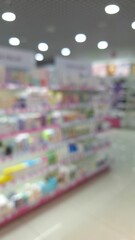 Blurred view of a well-lit store aisle with colorful products on shelves