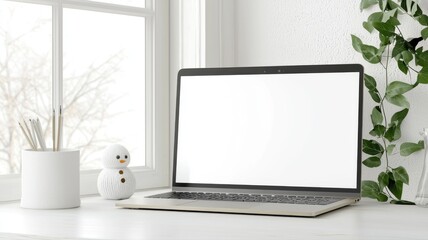 Obraz premium Modern workspace featuring a laptop, a cute snowman decoration, and green plant by the window for a cozy feel.