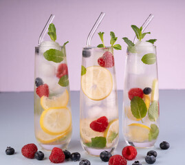 refreshing glasses of lemon berry infused water with mint garnish against a soft pastel background, perfect for a cool summer drink with a healthy, vibrant, and fresh appeal, stylish, organic