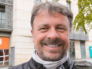 selfie portrait of happy handsome white man middle aged bearder in french city france