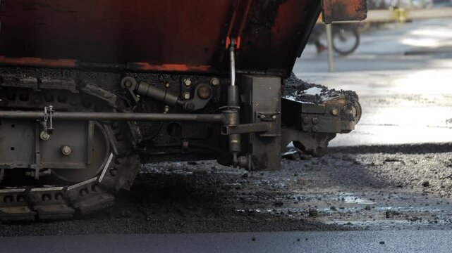 Detailed view of asphalt paving machine in urban environment on a sunny day