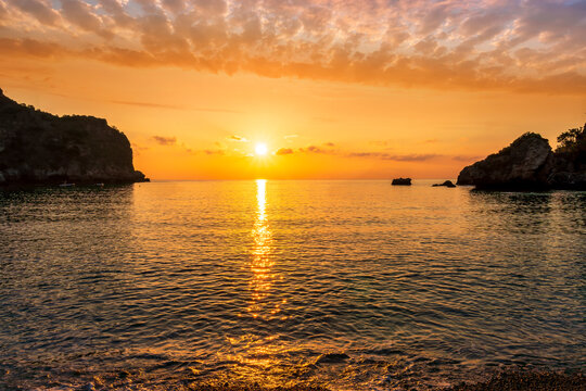 morning or evening landscape with nice beach , a sunrise or sunset in sea with amazing isle with rocks and beautiful clouds on background - Powered by Adobe