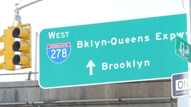 Brooklyn Queens expressway road sign, New York City highway signage, green traffic roadsign shield, United States transportation. One way arrow, yellow traffic light.