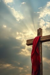 Cross with red cloth, dramatic sky background, Easter symbolism, religious faith, hope, spirituality, sunlight rays, reflection, resurrection theme, inspirational image.