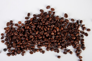 Pile roasted coffee beans isolated on a white background.