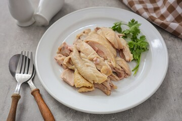 Boiled chicken in white plate on grey cememt background,hainanese chicken
