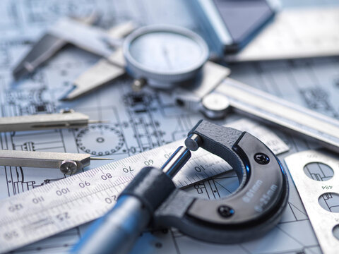 Close-up of engineering tools and blueprints for precision measurement and quality control