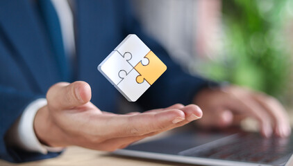 Problem solving strategy technique and solution concept, Businessman showing jigsaw icon on virtual screen. Jigsaw pieces that fit together demonstrate problem solving.