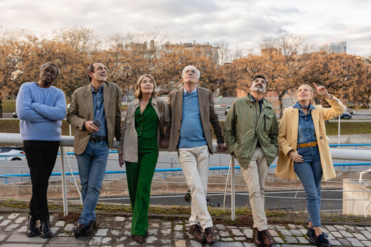 A group of seniors walking outdoors in a city park enjoying the autumn weather