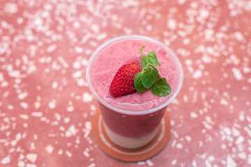 Glass of fresh strawberry milkshake or smoothie drink, top view