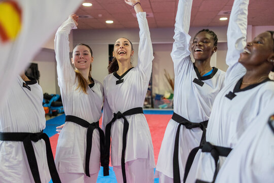 Group of young adults celebrating in a judo dojo