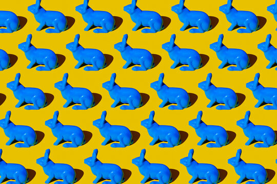 pattern, blue plastic rabbits, on a yellow background, toy, studio, indoors, repetition, herd