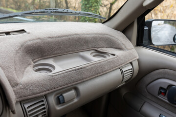 Close-up of an older 1996 4x4 American pickup truck dashboard with a beige fabric cover and...
