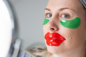 Close up of caucasian woman using a red collagen gel lip mask and green eye gel patches under her eyes