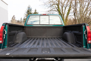  Rear angle of 1996 green 4X4 pickup truck with open tailgate, showing extended cab and empty bed liner in clean condition © Hrach