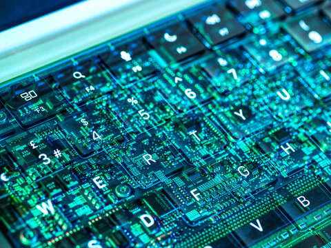 Futuristic view of a laptop keyboard with digital circuit overlay representing artificial intelligence and cybersecurity