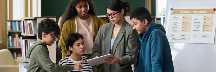 Teacher and students using a tablet during a lesson in a classroom