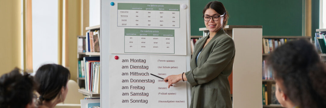 Teacher explaining language topic to a small group in a classroom