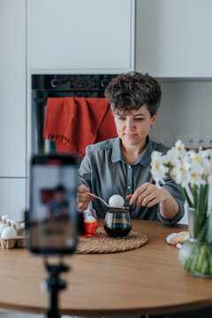 Woman creating an Easter egg dyeing tutorial at home