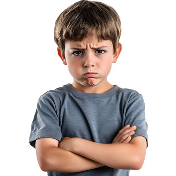 A young boy stands with his arms crossed, displaying a displeased and defiant expression. His furrowed brow emphasizes his mood.