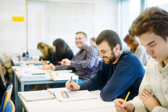 Adult students of different nationalities writing in a multicultural classroom
