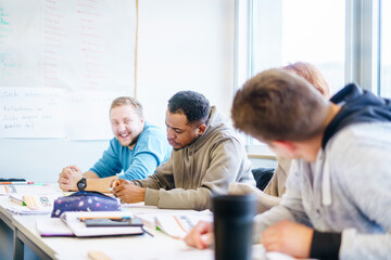 Students in a multicultural classroom engaging in conversation and collaborative learning