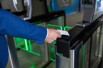 Close up picture of male hand with an access card on a security control