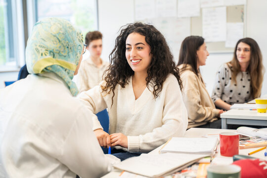 Students interacting in a multicultural classroom setting during an international language course