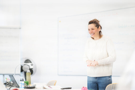Teacher explaining German rules in a friendly classroom atmosphere during an integration course session