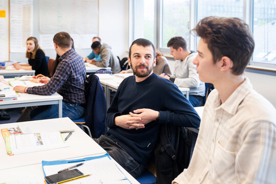 Students interacting in a multicultural classroom during an international language course