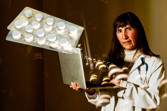 Doctor using laptop with 3D render of pills and medical visualization