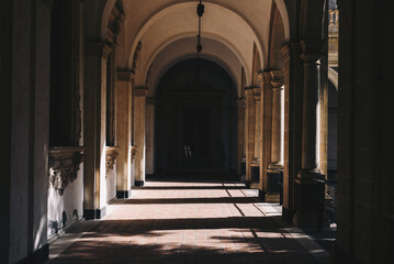 Long hallway with columns on both sides and entrance door in the end