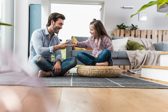 Father and daughter having fun at home sharing a high five