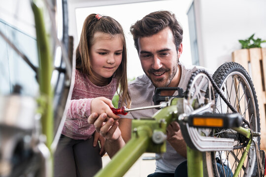 father,daughter,at home,having fun,love,quality time,inspiration,trust,security,care,repairing,bike