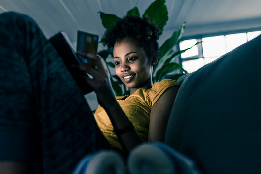 Woman at home using a tablet computer for online shopping with a credit card