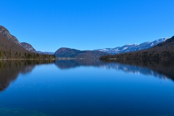 Fototapeta premium View of lake Bohinj and Rudnica hill with a reflection on the water surface in Gorenjska, Slovenia
