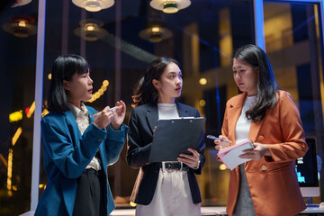 Businesswomen discussing strategy during night meeting in office