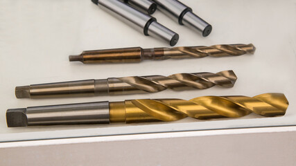 Twist drills with Morse taper shank. In the foreground is a drill with titanium nitride coating. © miraleks
