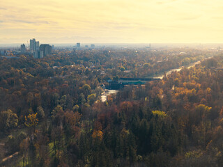 Stimmungsvolle Drohnenaufnahme bei Sonnenuntergang über den Englischen Garten mit Blick auf den Arabellapark im Münchner Osten