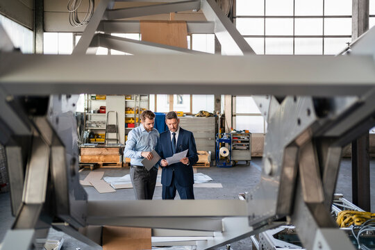 Two businessmen having a meeting in a factory